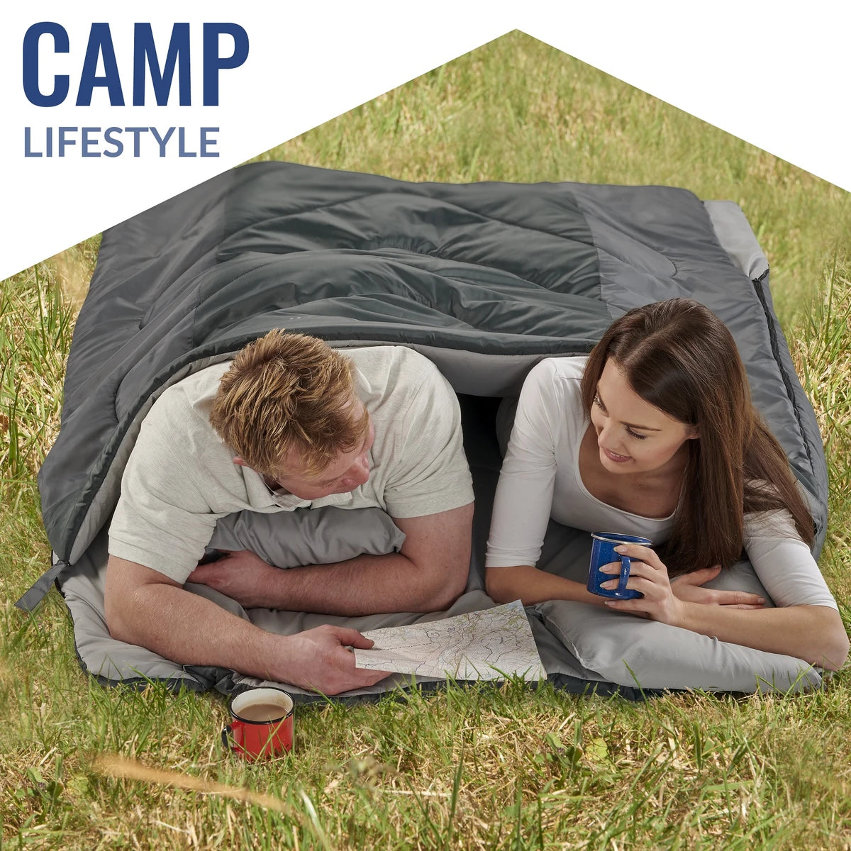 Couple lying in the VENTURE 4TH double sleeping bag on grass